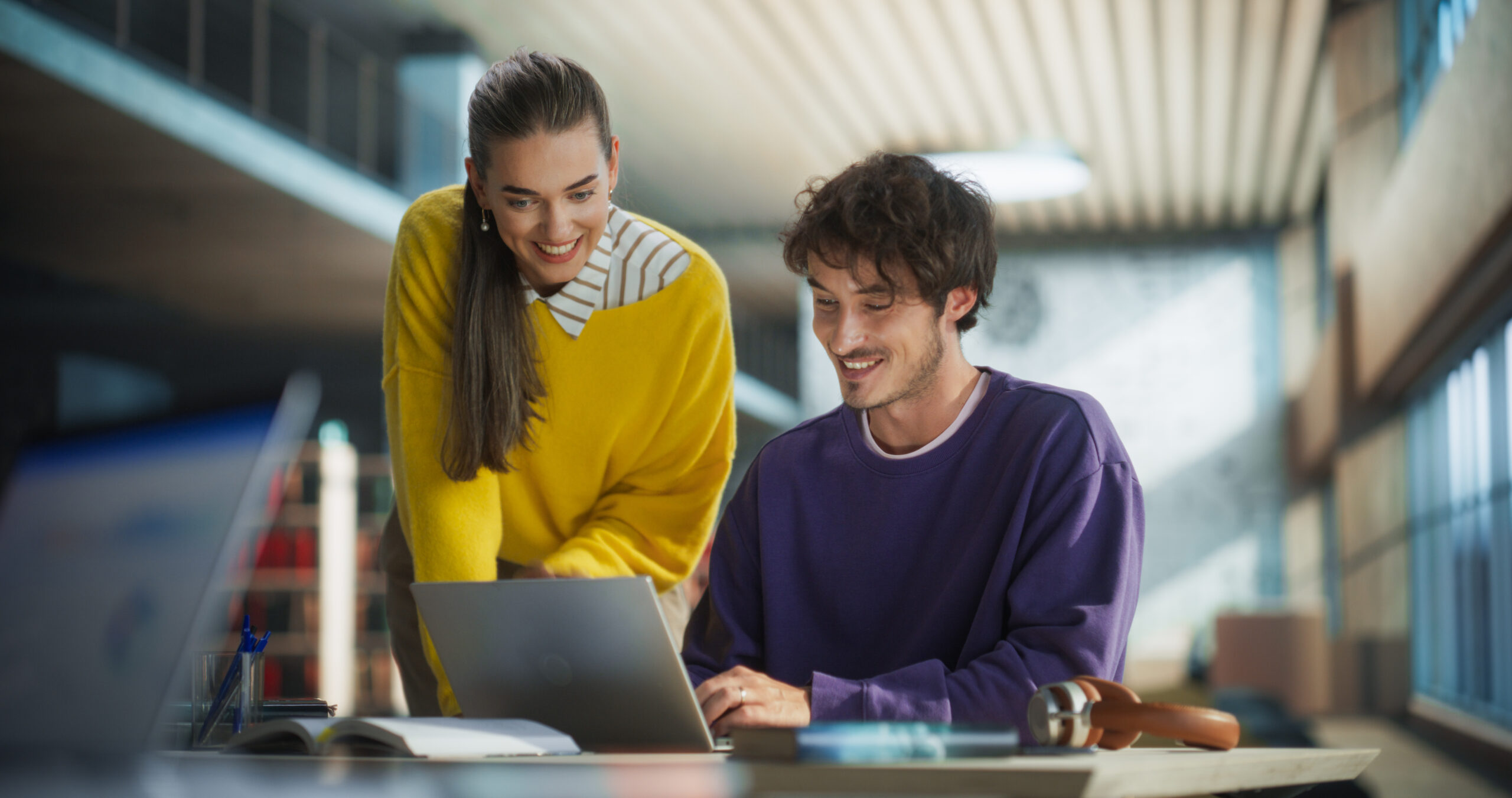 Zwei Fachkräfte arbeiten gemeinsam am Laptop während eines Schulungs Webinars.